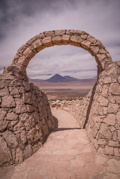Stone gate at Pukara de Quitor - Inca fortress at Atacama desert with the view at Licancabur volcano in Andes, San Pedro de Atacama, Chile