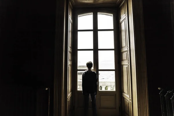 Un niño triste Mirando por la ventana en el lago Como en la temporada de verano —  Fotos de Stock