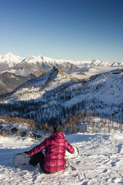 Snowboardåkare tjej att ta vila och meditera på toppen av mo — Stockfoto