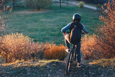 Gün batımından önce bir tepenin kenarında dağ bisikletçinin tezgahı kurtulmak