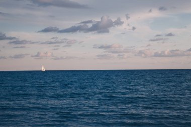 Yalnız yelken ve gün batımında deniz deniz manzarası görünümünü kış sezon 