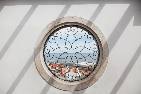 Circle window - Santa Luzia viewpoint (miradouro), with view to Alfama old town and Tagus river - Lisbon, Portugal