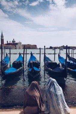 Venedik - St Marco veya Saint Mark's Meydanı - ham güneş koruma kavramı güneşte tarafından iki halk ile kapsayan elbise