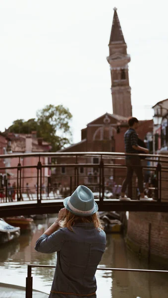 Baksidan på ung flicka tar foto på klocktornet på ön av Burano i lagunen i Venedig - Italien. — Stockfoto