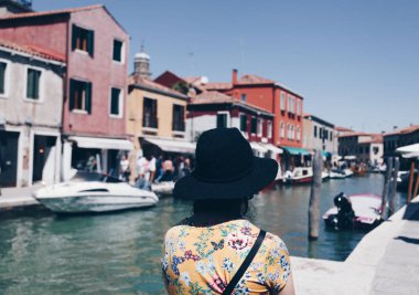 Murano Venedik adlı kanal üzerinde şapkalı bir kız arkadan görünüm