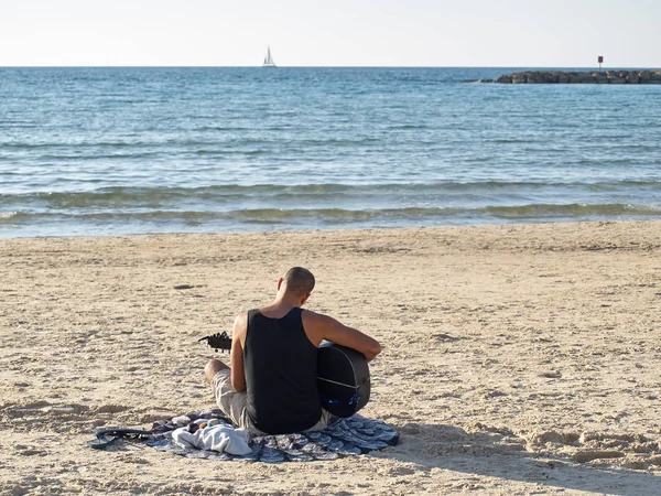 Мальчик играет на гитаре на пляже в солнечный день . — стоковое фото