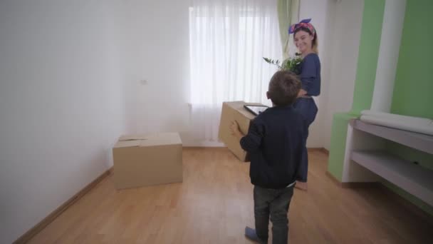 Familie zieht um, behinderter Vater im Rollstuhl mit lächelnder Frau und fröhlichem Sohn richtet sich ein und genießt neue Wohnung — Stockvideo