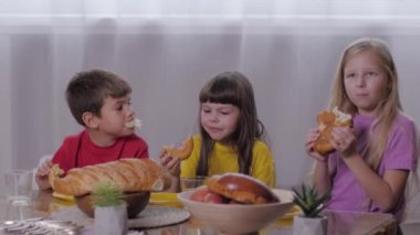 Taze hamur işleri, güzel çocuklar tatlı masada çocuk partisinden sonra tatlı çörekler yemekten hoşlanırlar.