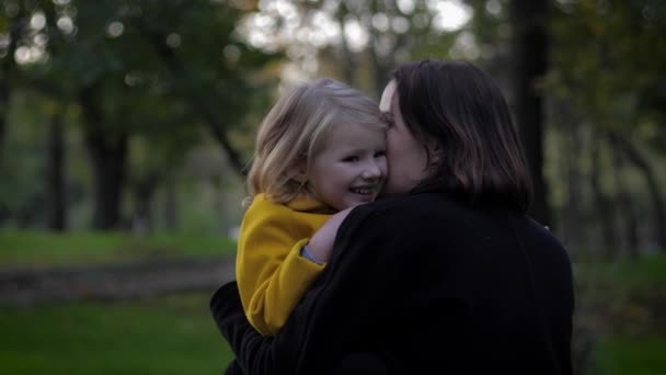 Tempo felice, madre sensibile gioca con attenzione con la sua affascinante figlia nel prato nel parco autunnale durante le vacanze in famiglia — Video Stock