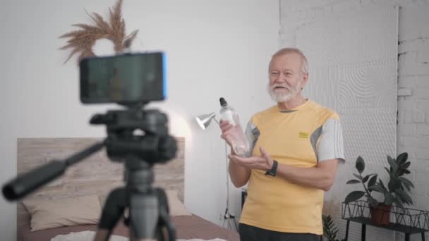 Old man Influenciadores blogando sobre estilo de vida saudável exercícios de gravação de conteúdo na câmera do telefone durante uma transmissão ao vivo — Vídeo de Stock