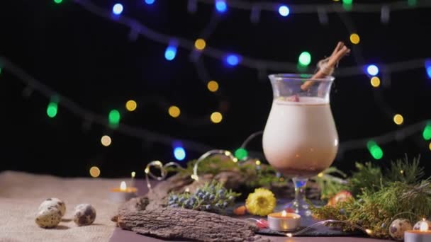 Feestelijke tafel, een prachtig glas met traditionele eiercocktail versierd met kerstboom en lichtjes, eierpunch — Stockvideo