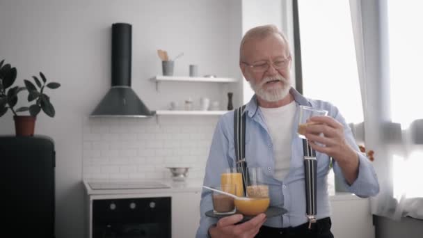 Wholesome products, an elderly smiling man in glasses for vision, who cares about health, talks about cereals keeps food in hands — Stock Video