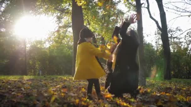 Vztah dětí a rodičů, starostlivá matka objímá svou krásnou dceru na procházku v krásném podzimním parku, outdoorové aktivity — Stock video