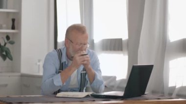 Modern yaşlı erkek sağlıklı yiyecekler hakkında blog tutmaya devam ediyor. Sağlıklı yiyecekler hakkında arka planda cep telefonuna vlog yazarak sağlıklı yiyecekler gösteriyor.