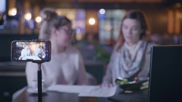 Voedingsdeskundige blogger, modieuze Influencers praat over voeding voor overgewicht meisje toont dieet plan en calorie tellen tijdens het zitten in cafe aan tafel tijdens live-uitzending — Stockvideo