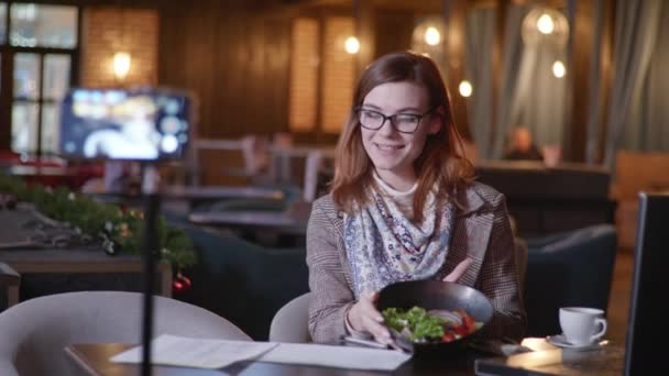 Blogger Ernährungswissenschaftler leitet Live-Übertragung für Blog aus einem teuren Restaurant und spricht über die Vorteile der richtigen Ernährung und Diätplan für Anhänger während des Urlaubs im trendigen Café — Stockvideo