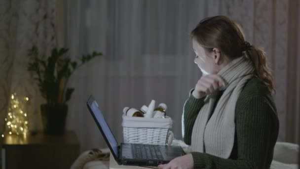 Ongezonde vrouw hoest en gebruikt medicijnen voor gewone verkoudheid, niest en lijdt keelpijn tijdens griep en koude seizoen, influenza meisje zit thuis op zieke man met laptop kijken — Stockvideo