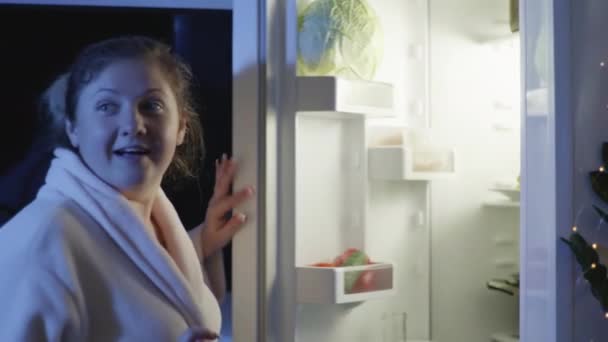 Harm to health, a hungry housewife comes to kitchen at night and takes out junk food from burger and bites him with great pleasure, concept of happiness — Stock Video