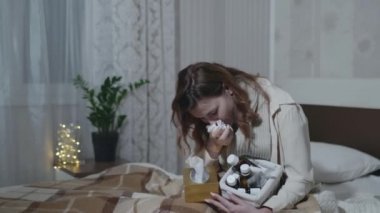 Grip olmuş bir kız hasta öksürüyor ya da nezle olmuş. Soğuk algınlığı için ilaç alıyor. Oda odasındaki kanepede sıcak bir battaniyenin altında oturuyor.