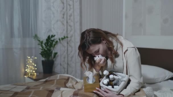 Грип дівчина хвора кашель від застуди або грипу страждає від високої температури приймає ліки від застуди, захищеної теплою ковдрою на дивані в кімнаті — стокове відео