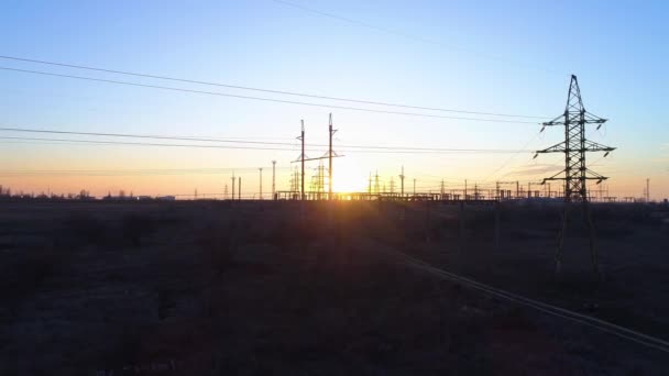 Problème d'électricité et d'environnement, vue aérienne des tours à haute tension et des lignes électriques sous le beau coucher de soleil orange — Video