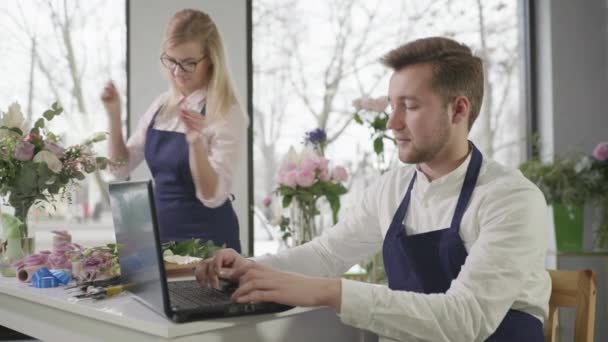 Online služba, moderní mladí specialisté přijímat on-line nákupy v květinářství, profesionální květinářství kytice květiny k dodání, malý obchodní koncept — Stock video