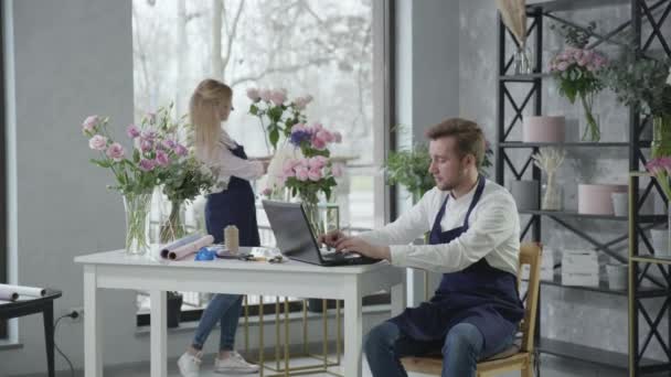 Klein bedrijf, jong team van bloemisten werkt in de bloemenwinkel en neemt bestellingen online voor de levering van bloemen, carrière succes — Stockvideo