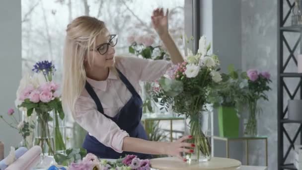 gender equality, young attractive blonde entrepreneur, owner of successful small business, prepares modern fresh bouquets of flowers for sale and delivery in flower shop, startup