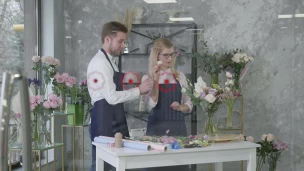 Mladý atraktivní chlapec a dívka květinářství úspěšní malí podnikatelé pracují v květinářství a vytvořit moderní kytice květin na prodej nebo doručení, týmová práce — Stock video