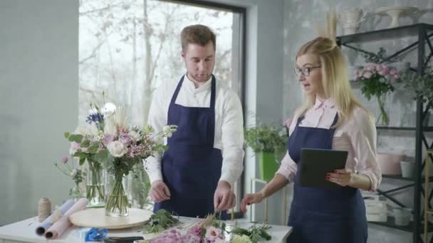 Kisvállalkozás, fiatal vállalkozók férfi és nő virágüzlet megnyitó gyűjteni eladó és szállítási csokor virág, csapatmunka — Stock videók