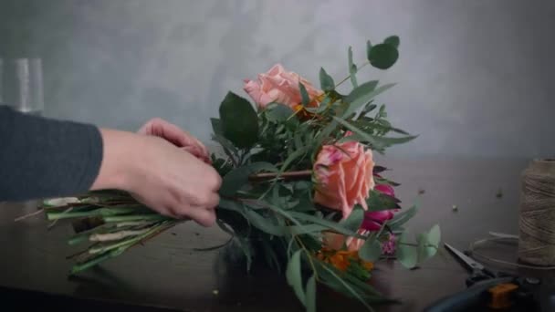 Diseño floral, floristería femenina profesional trabaja en la tienda florística y hace ramo de flores lo ata con cordel, pequeña empresa — Vídeo de stock