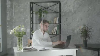 Bilgisayarda çalışan genç erkek girişimcinin portresi, online muhasebe hesaplarını kontrol ediyor,