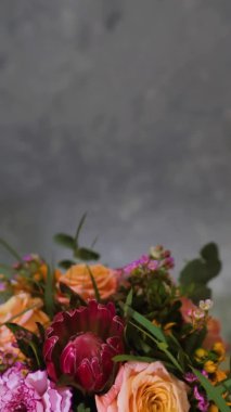 vertical screen, bouquet of flowers rotates dark background with place for inscription, floral business