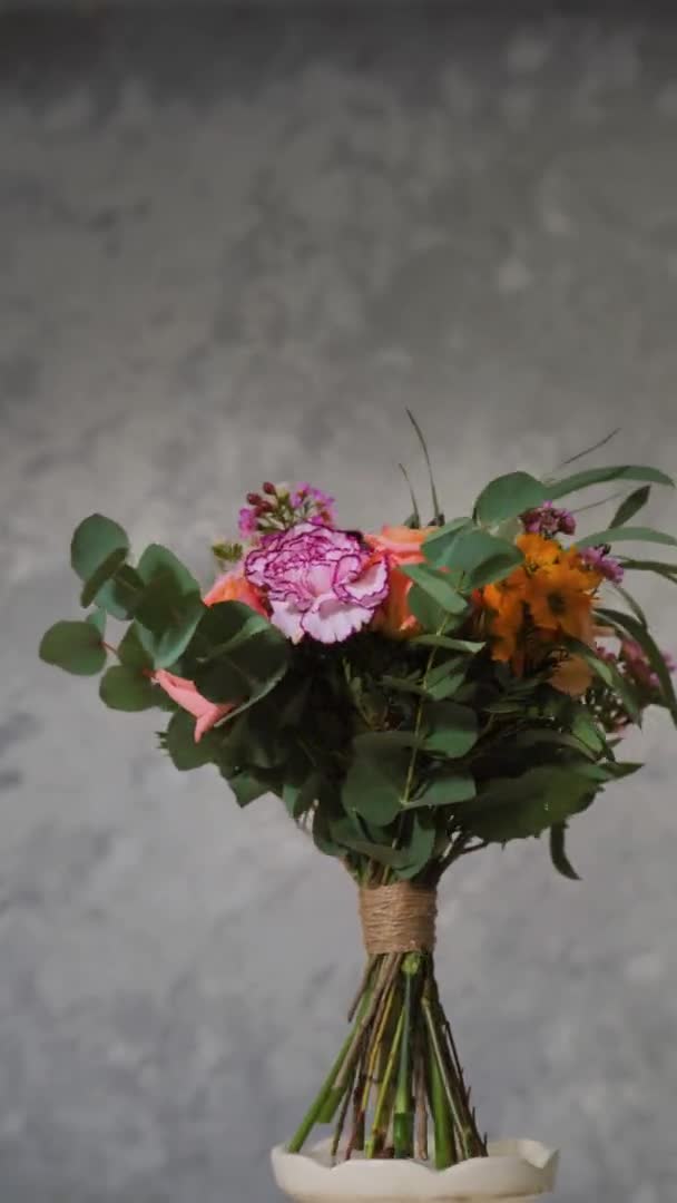 Vertical screen, floral arrangement showing beauty of flowering created by florist, bouquet of flowers rotates dark background with place for inscription — Stock video