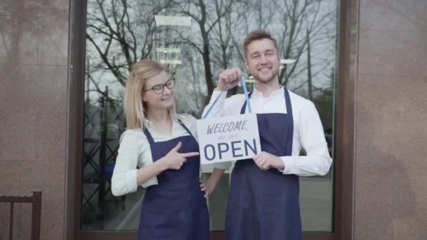 Retrato jóvenes socios se alegran de la apertura del éxito de las pequeñas empresas, empresarios mujer y hombre invitan a la tienda de pie con una tableta abierta en las manos — Vídeos de Stock