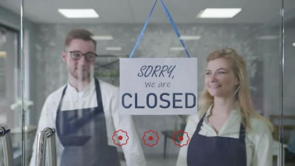 Streich, junge Geschäftsleute freuen sich, Geschäft und Kleinunternehmen zu öffnen, wechseln das Schild von Geschlossen zu Öffnen, zeigen mit dem Finger darauf und es fällt, Mann und Frau lachen, Fake — Stockvideo