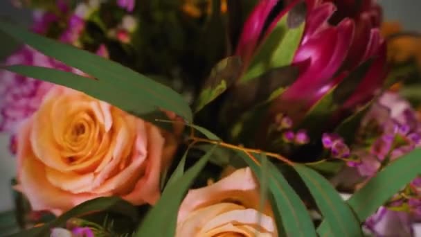 Bouquet de flores de design moderno feito para entrega ou venda de florista loja por florista criativo profissional gira em fundo escuro, close-up — Vídeo de Stock