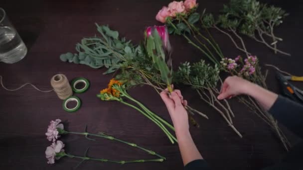 Flower shop, professional florist female prepares flowers to bouquet for sale in floristic studio, floral business concept — 비디오