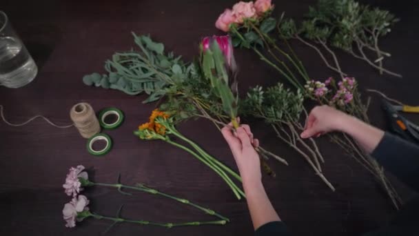 Flower shop, professional florist female prepares flowers to bouquet for sale in floristic studio, floral business concept — Wideo stockowe