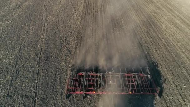 Bebouwing, landbouwtrekker met ploeg cultiveert grond op het veld voor het zaaien van landbouwgewassen — Stockvideo