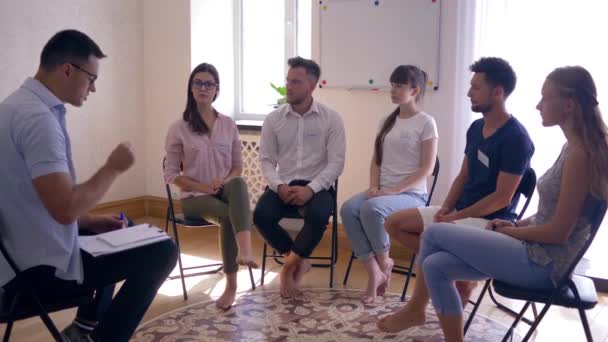 Psicoterapia de grupo, mujer hablando de problemas y compartiendo emociones de pie frente a las personas — Vídeo de stock