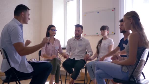 Lidé meditující se zavřenýma očima sedící na židlích během terapie — Stock video