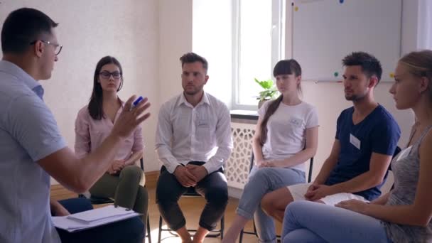 Man talking and sharing emotions during therapy session standing in circle of people — Wideo stockowe