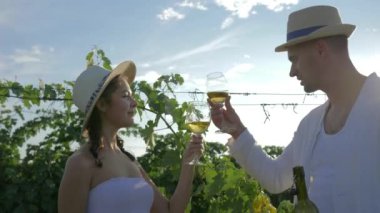 rural couple of winemakers drinking alcoholic beverage during autumn harvest on vineyard plantation
