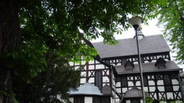 Yeşil ağaçların yanındaki büyük ahşap dini bina.