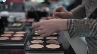 emale alıcı kozmetik mağazasında cilt rengine uyması için makyaj vakfı temeline başvuruyor.