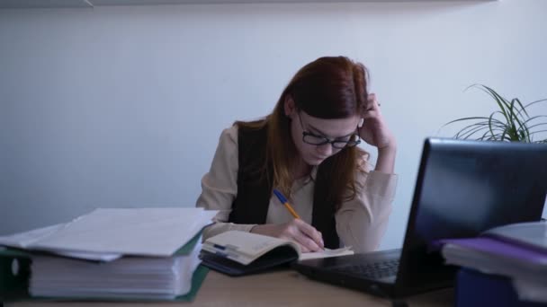 Junge schöne arbeitende Frau ist sehr müde nimmt die Brille ab und reibt sich müde Augen, wenn sie am Arbeitstag mit Laptop am Tisch im Büro sitzt, Probleme mit Brille, Sehvermögen oder Sehvermögen — Stockvideo