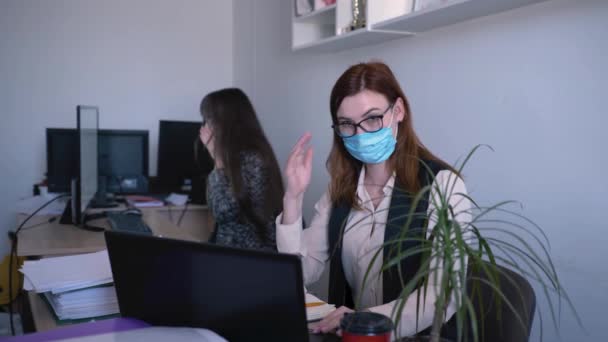 Hälsoskydd, kvinnlig anställd i medicinsk mask använder ett antiseptiskt medel för att förhindra virus och infektion på ett kontor nära sjuk kollega — Stockvideo