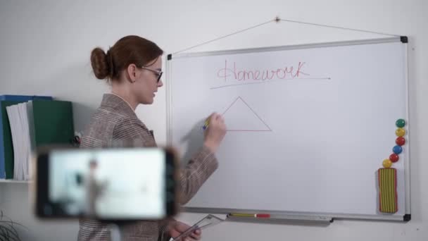 Enseignement à distance pour les écoliers, jeune professeur moderne mène des leçons en ligne pour les étudiants utilisant un smartphone pendant la quarantaine, enseignant aux enfants — Video