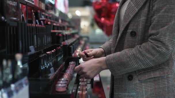장식용 화장품가게, 여자 구매자는 립스틱을 검사하여 판매중에 손에 얹는다 — 비디오